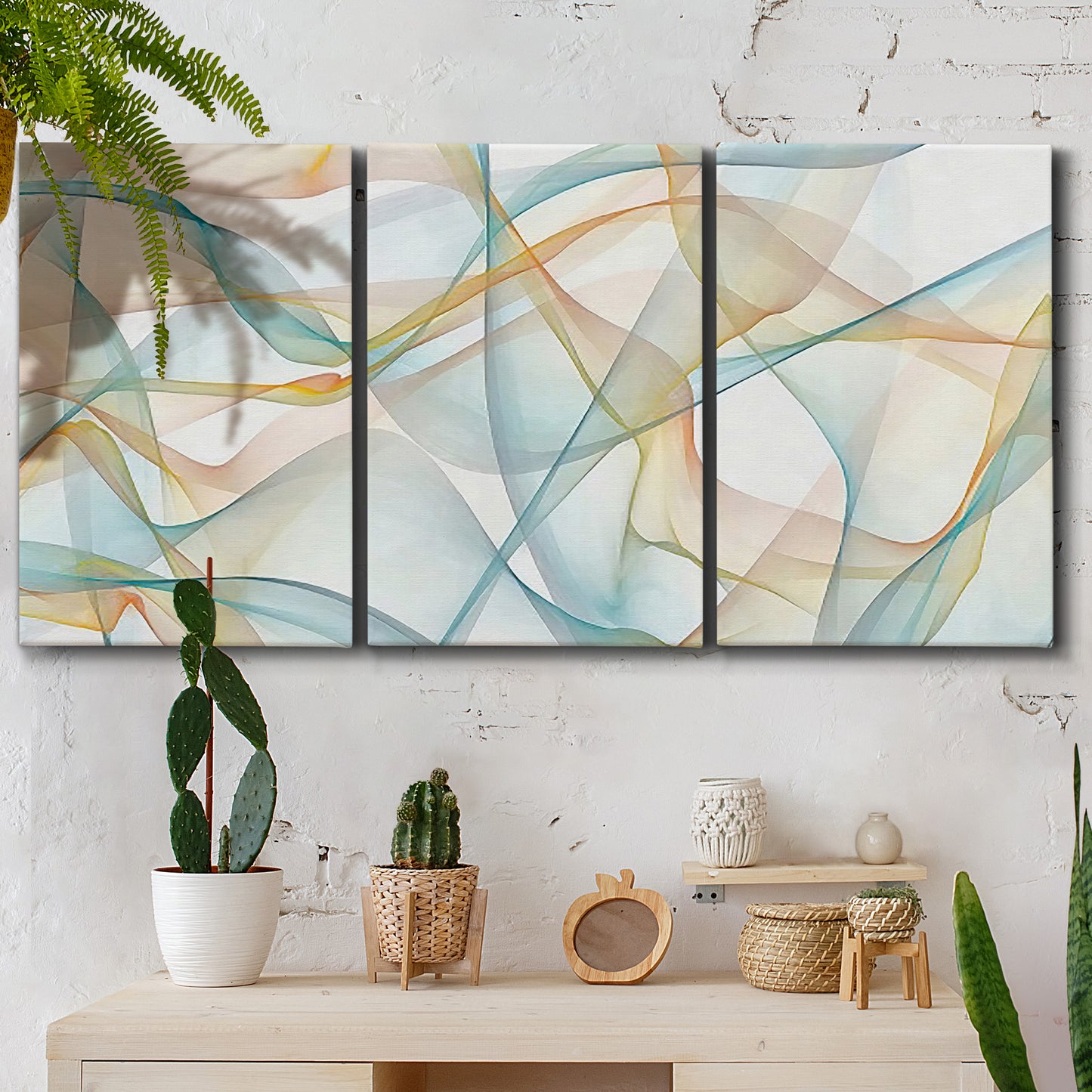 Three-panel canvas wall art featuring flowing abstract curves and wave patterns, displayed in a boho-chic entryway above a console table.