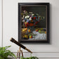 Impressionist floral still life painting by Claude Monet in an ornate black frame with gilded inner detail displayed in a light-toned interior setting.