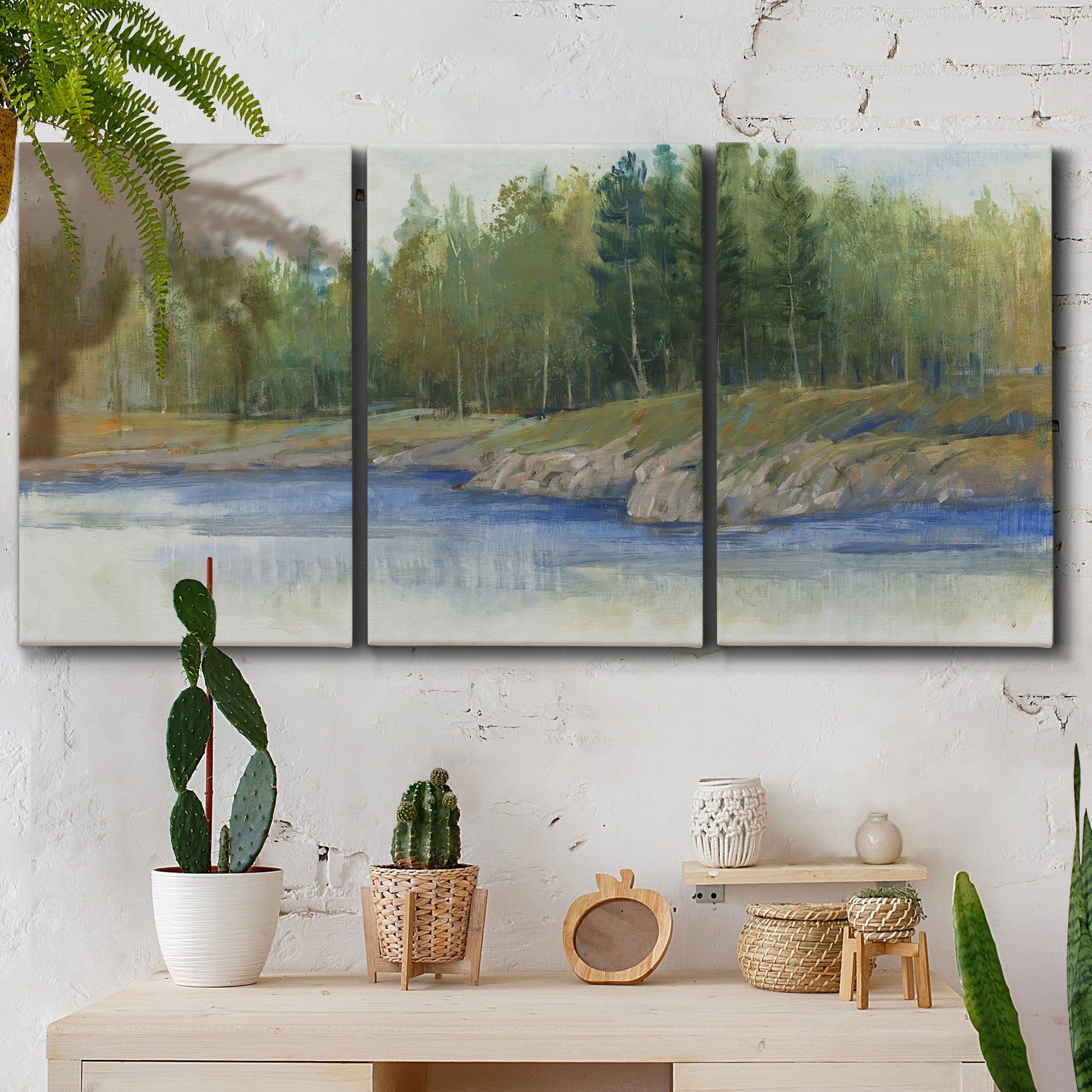 Three-panel canvas wall art featuring riverbank landscape with trees, displayed in a boho-chic entryway above a console table.