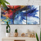 Three-panel canvas wall art featuring vibrant abstract color explosion, displayed in a boho-chic entryway above a console table.
