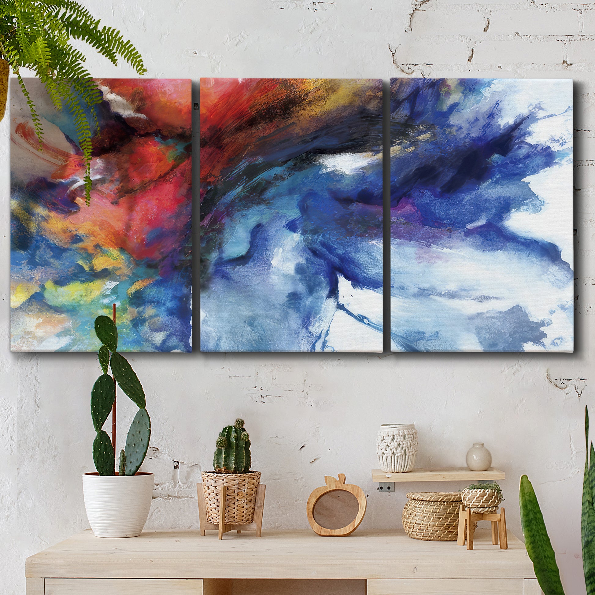 Three-panel canvas wall art featuring vibrant abstract color explosion, displayed in a boho-chic entryway above a console table.