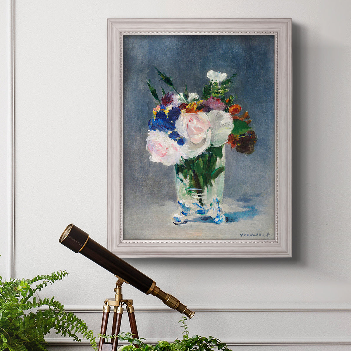 Impressionist floral still life painting by Claude Monet in an ornate weathered white frame displayed in a light-toned interior setting.