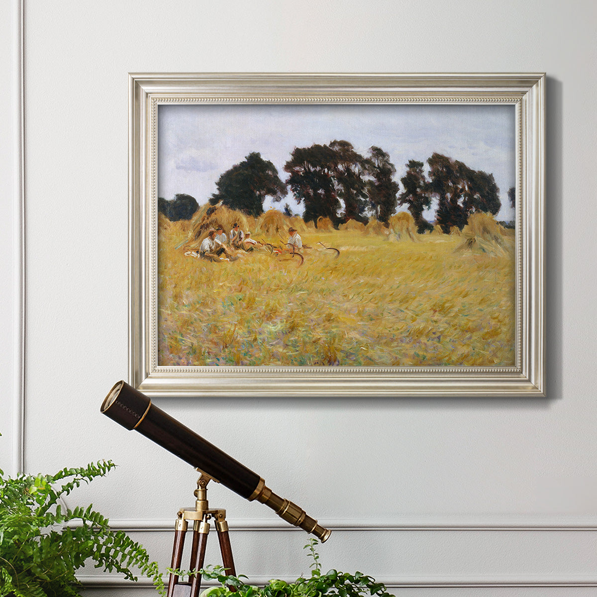 Impressionist rural harvest scene by John Singer Sargent in an ornate champagne frame displayed in a light-toned interior setting.