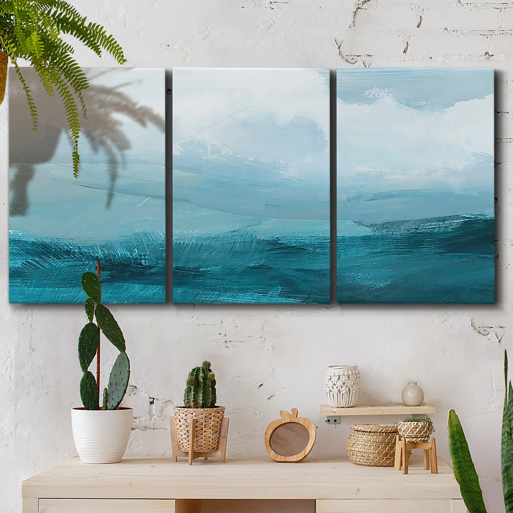 Three-panel canvas wall art featuring vertical coastal elements with rising light, displayed in a boho-chic entryway above a console table.