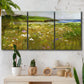 Three-panel canvas wall art featuring rugged coastal cliff landscape, displayed in a boho-chic entryway above a console table.