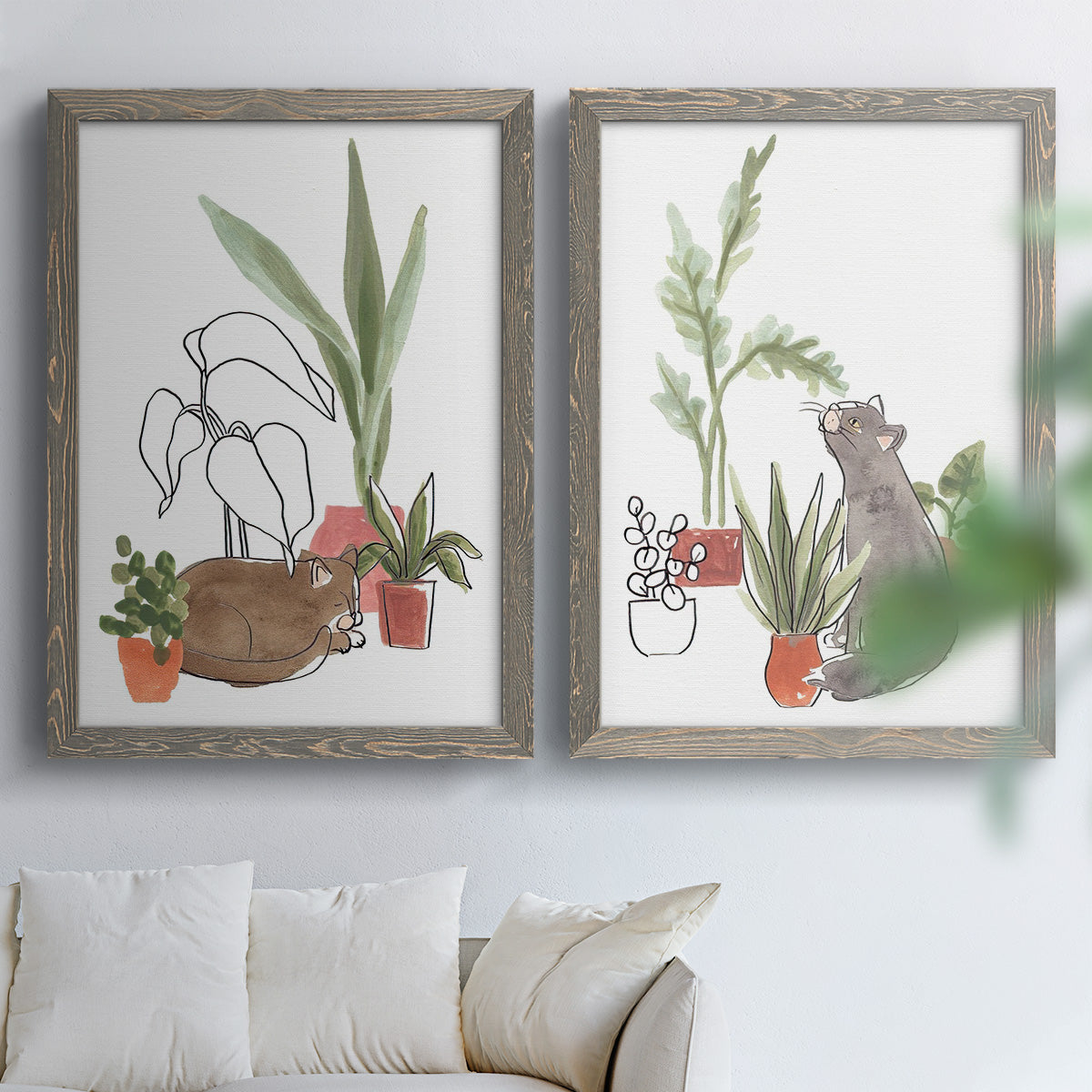 Set of two gray barnwood framed canvas prints depicting curious felines, terracotta pots, succulents, and leafy stems arranged across two complementary compositions above a sofa in a bright living space.