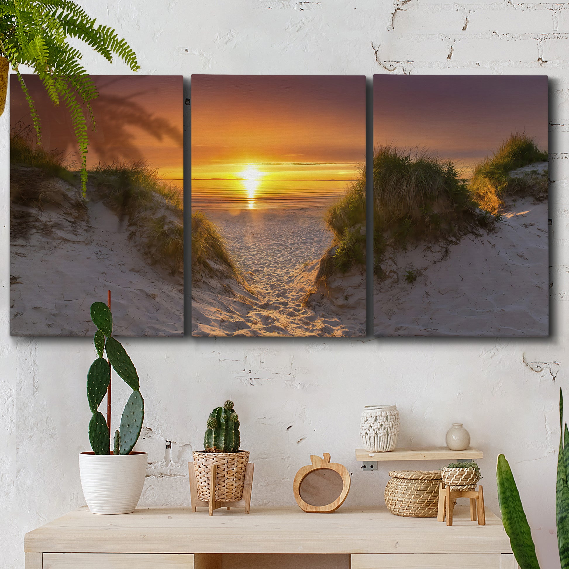 Three-panel canvas wall art featuring sunlit tropical path through greenery, displayed in a boho-chic entryway above a console table.