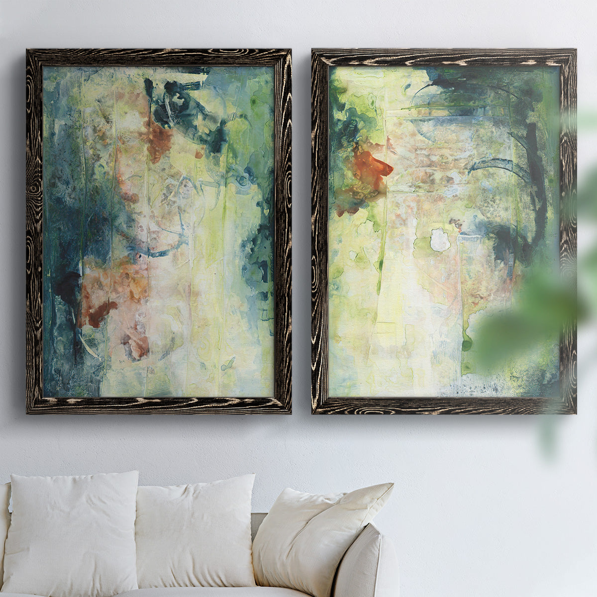 Set of two black barnwood framed canvas prints depicting vertical organic marks, pale light passages, and weathered surfaces arranged across two complementary compositions above a sofa in a bright living space.