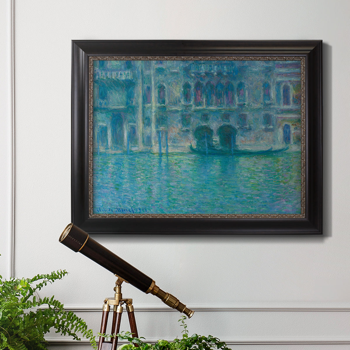 Impressionist Venetian palace waterfront scene by Claude Monet in an ornate black frame with gilded inner detail displayed in a light-toned interior setting.