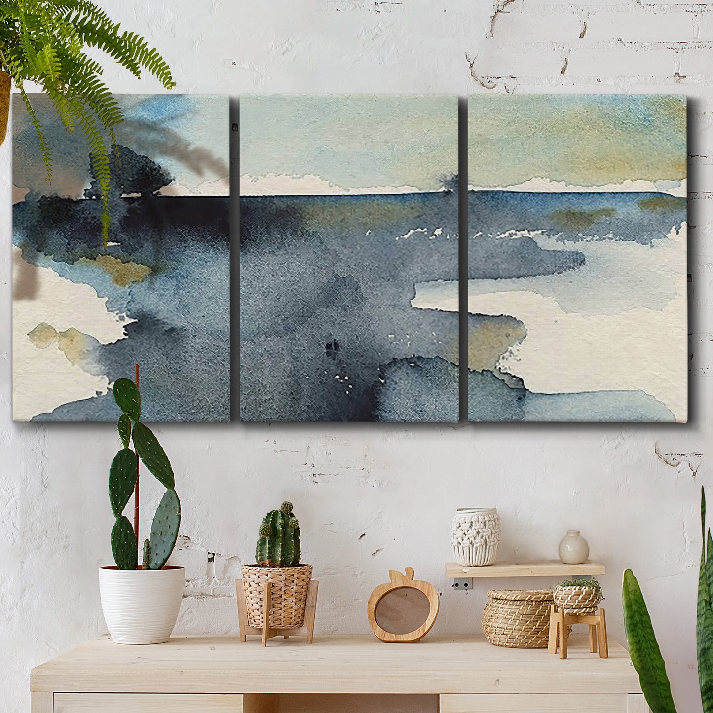 Three-panel canvas wall art featuring abstract watercolor with upward motion, displayed in a boho-chic entryway above a console table.