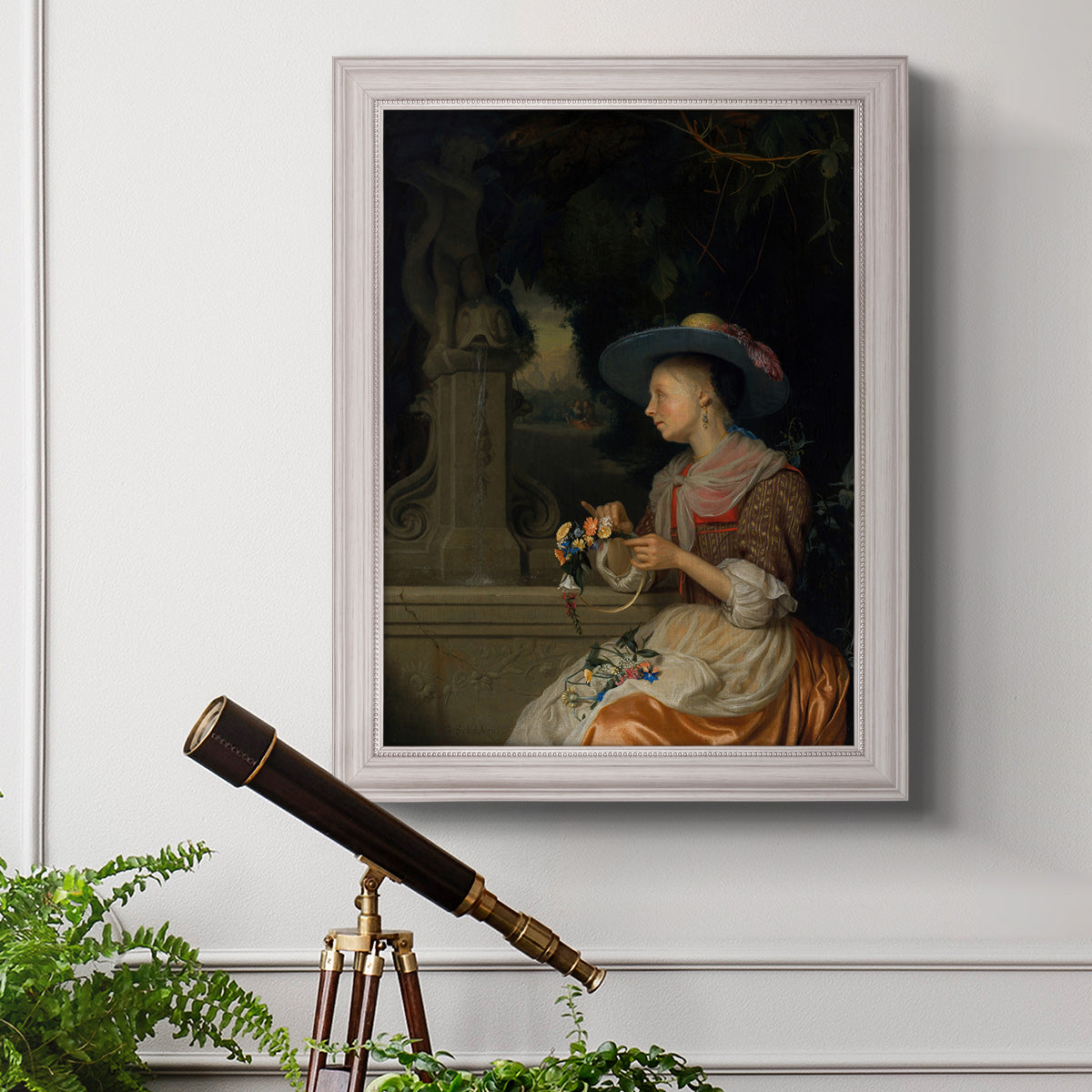 Classical interior scene of a woman weaving flowers by Godfried Schalcken in an ornate weathered white frame displayed in a light-toned interior setting.