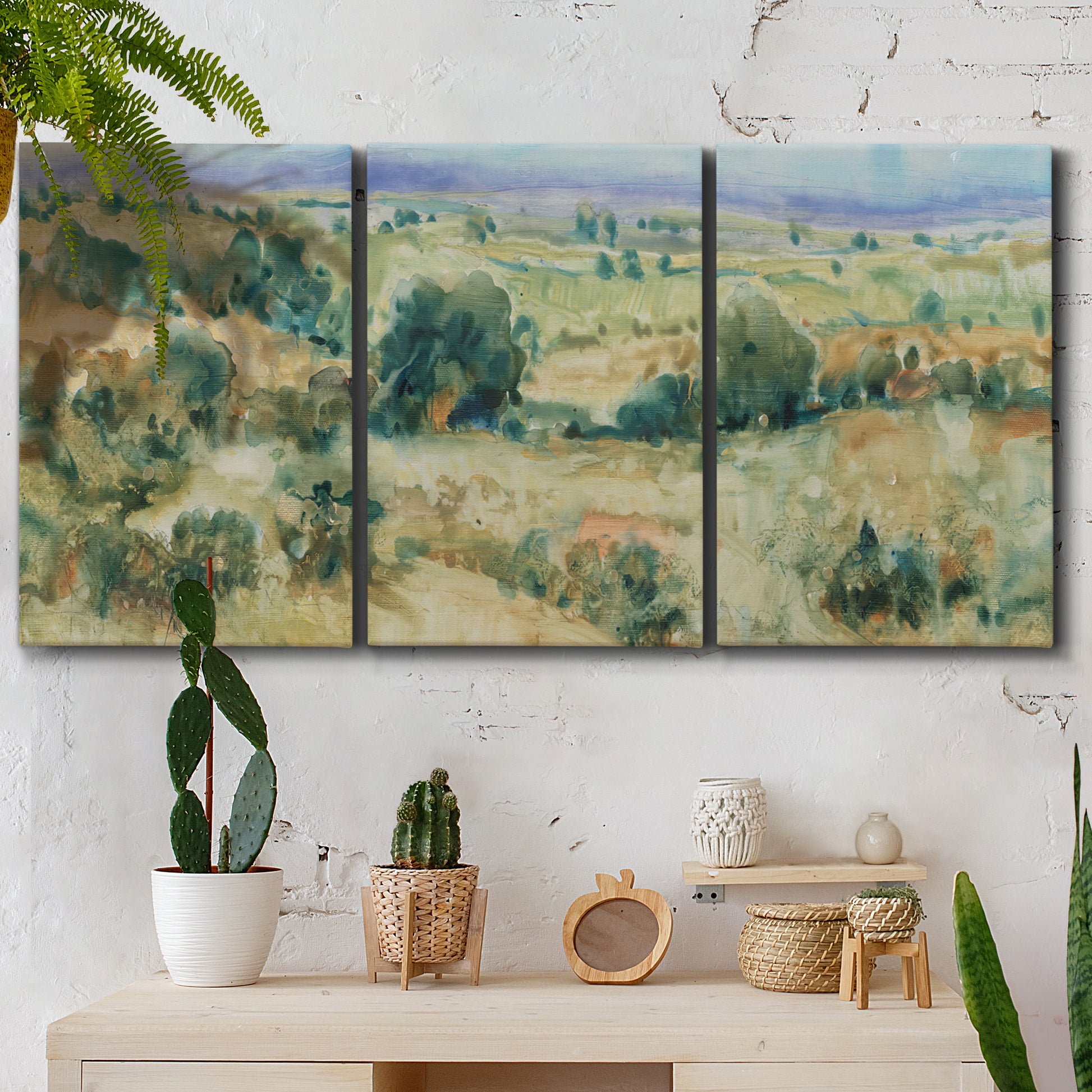 Three-panel canvas wall art featuring lavender sky over quiet landscape, displayed in a boho-chic entryway above a console table.
