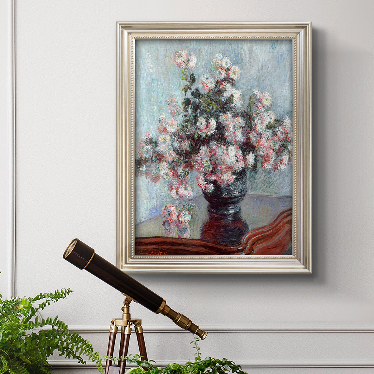 Impressionist chrysanthemum floral painting by Claude Monet in an ornate champagne frame displayed in a light-toned interior setting.
