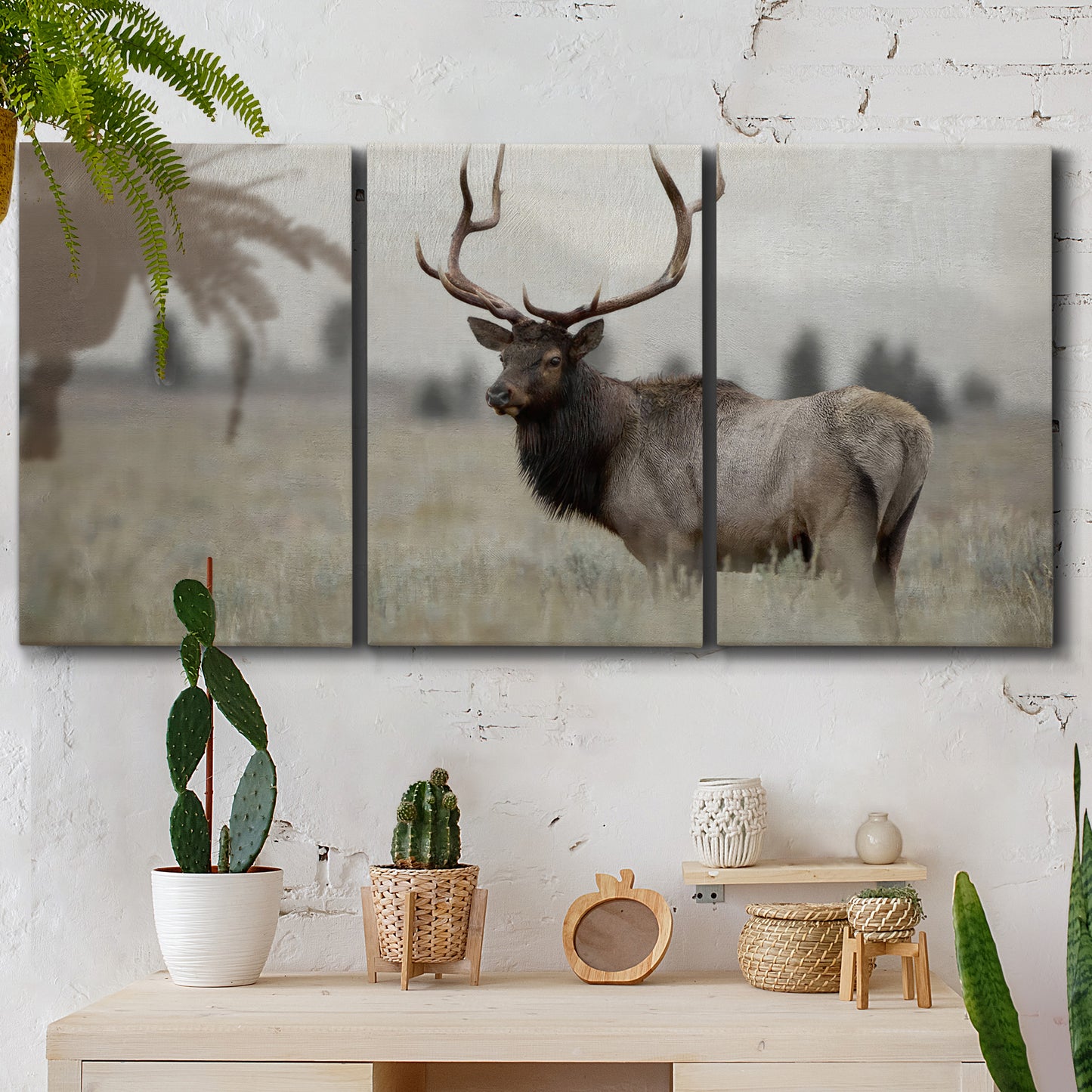 Three-panel canvas wall art featuring elk standing in open grassland, displayed in a boho-chic entryway above a console table.