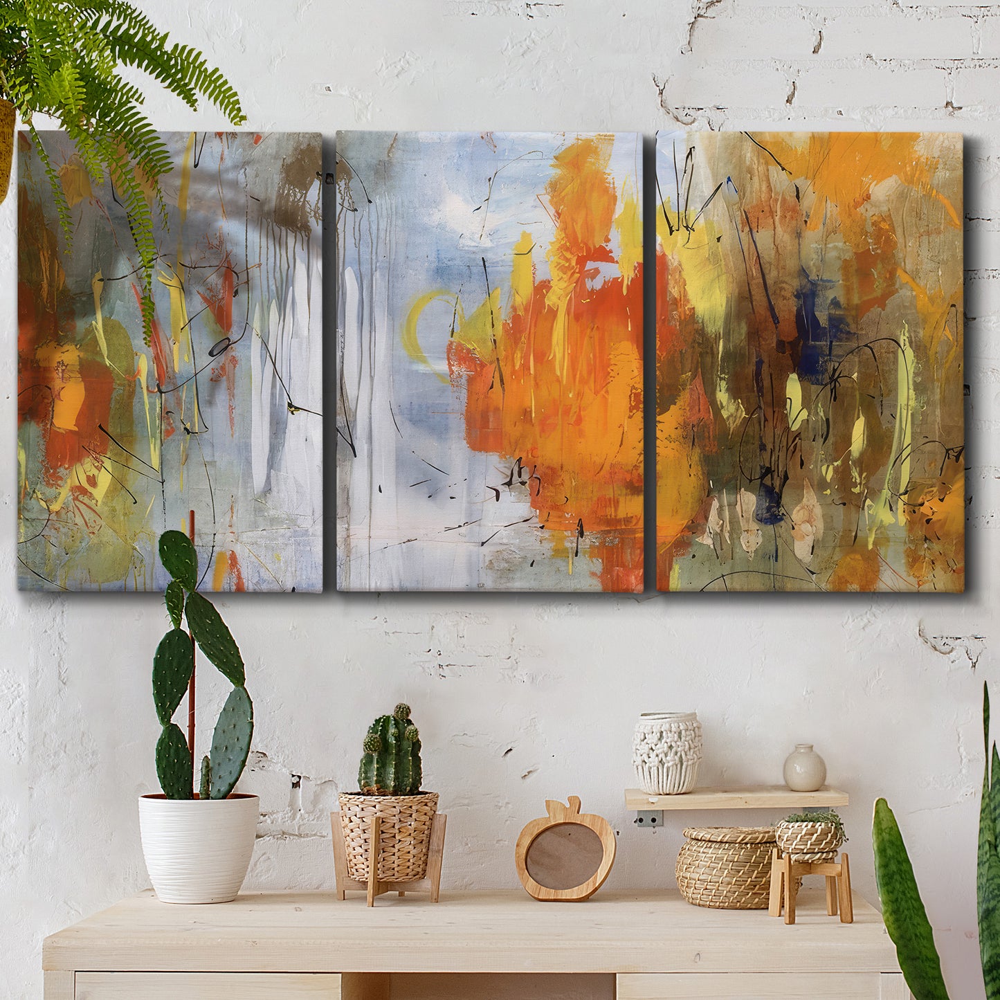 Three-panel canvas wall art featuring abstract warm sunset tones, displayed in a boho-chic entryway above a console table.
