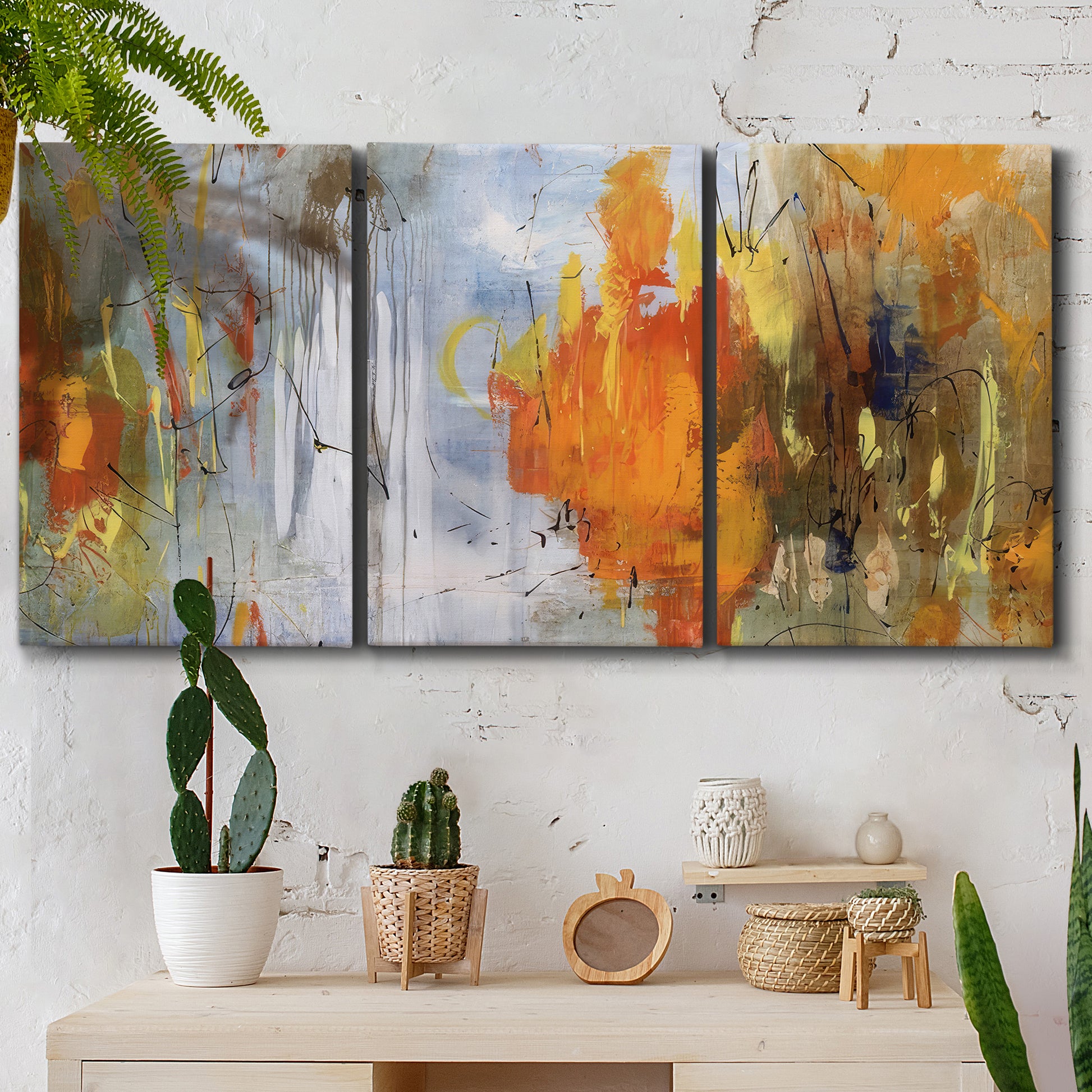 Three-panel canvas wall art featuring abstract warm sunset tones, displayed in a boho-chic entryway above a console table.