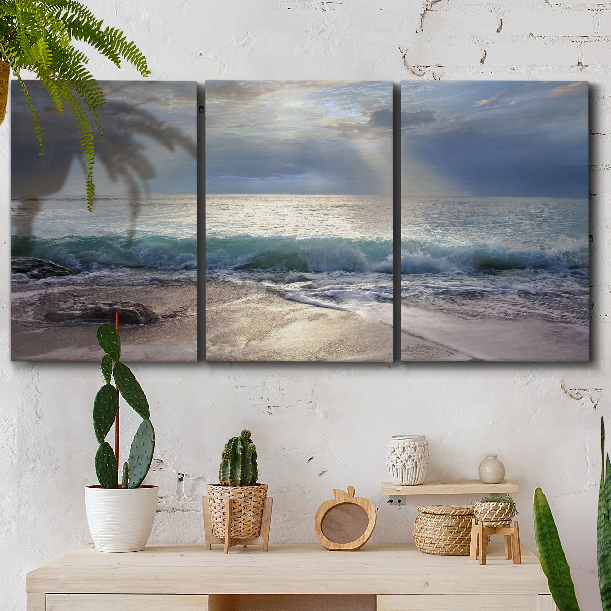 Three-panel canvas wall art featuring soft sunrise over open water, displayed in a boho-chic entryway above a console table.