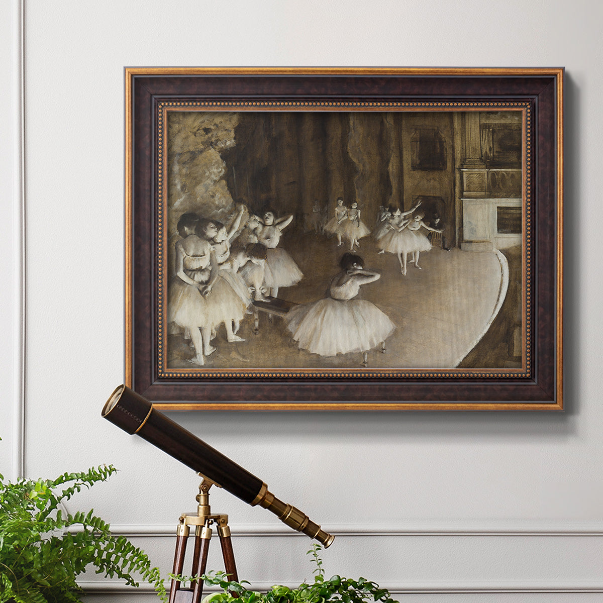 Impressionist ballet rehearsal scene by Edgar Degas in an ornate bronzed mahogany wood frame displayed in a light-toned interior setting.
