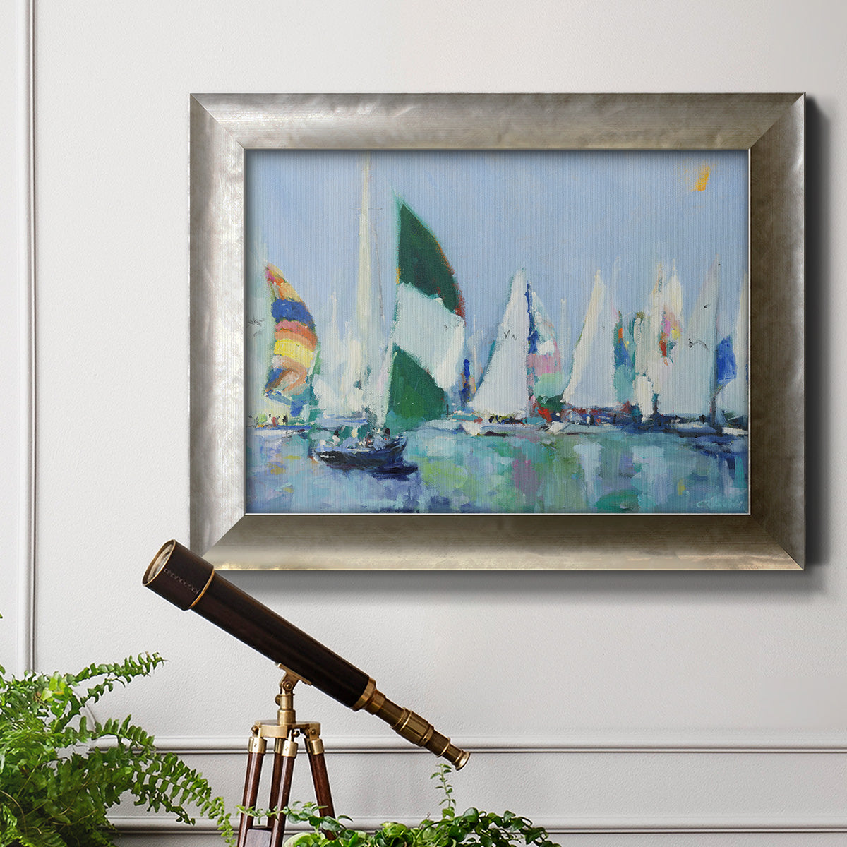 Coastal harbor watercolor painting in an ornate mottled silver frame displayed in a light-toned interior setting.