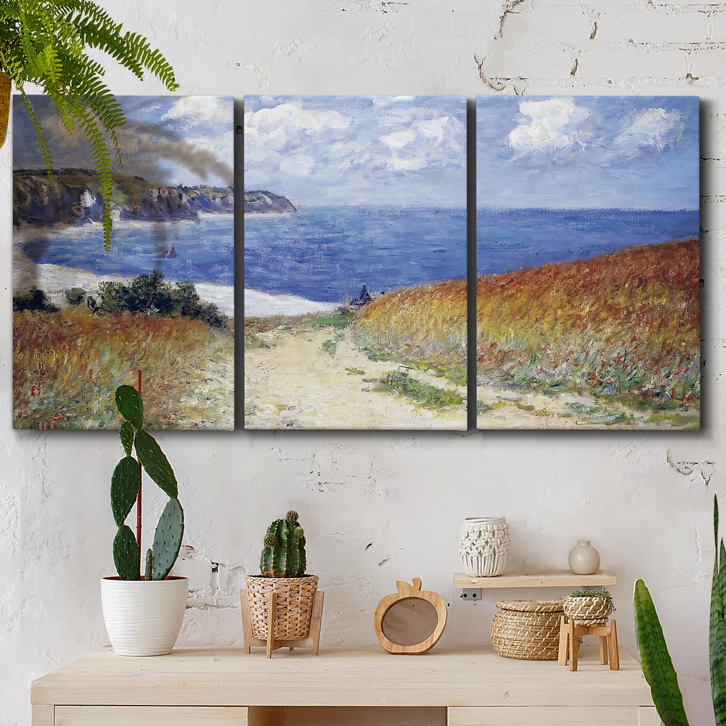 Three-panel canvas wall art featuring coastal path leading to sea, displayed in a boho-chic entryway above a console table.
