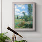 Impressionist pastoral landscape with poppy fields by Claude Monet in an ornate weathered white frame displayed in a light-toned interior setting.