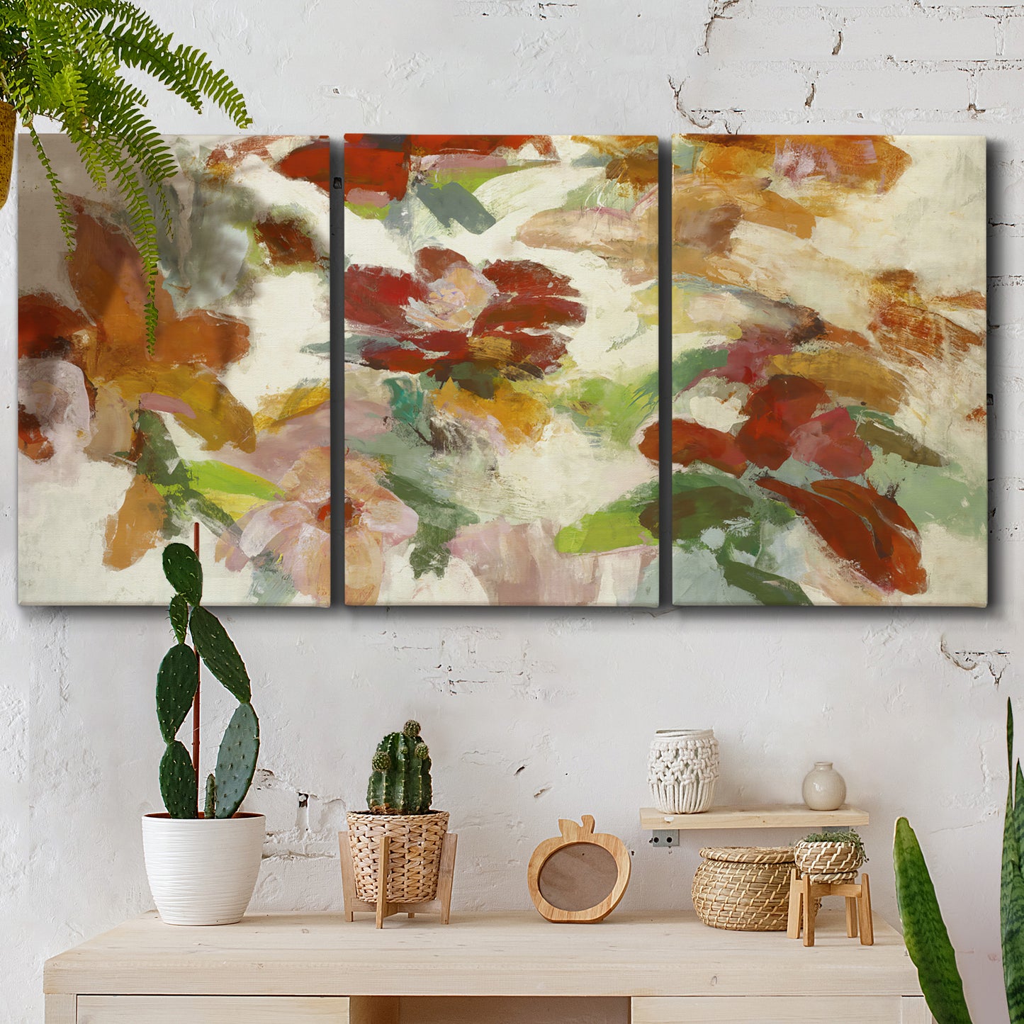 Three-panel canvas wall art featuring layered floral botanical impressions, displayed in a boho-chic entryway above a console table.