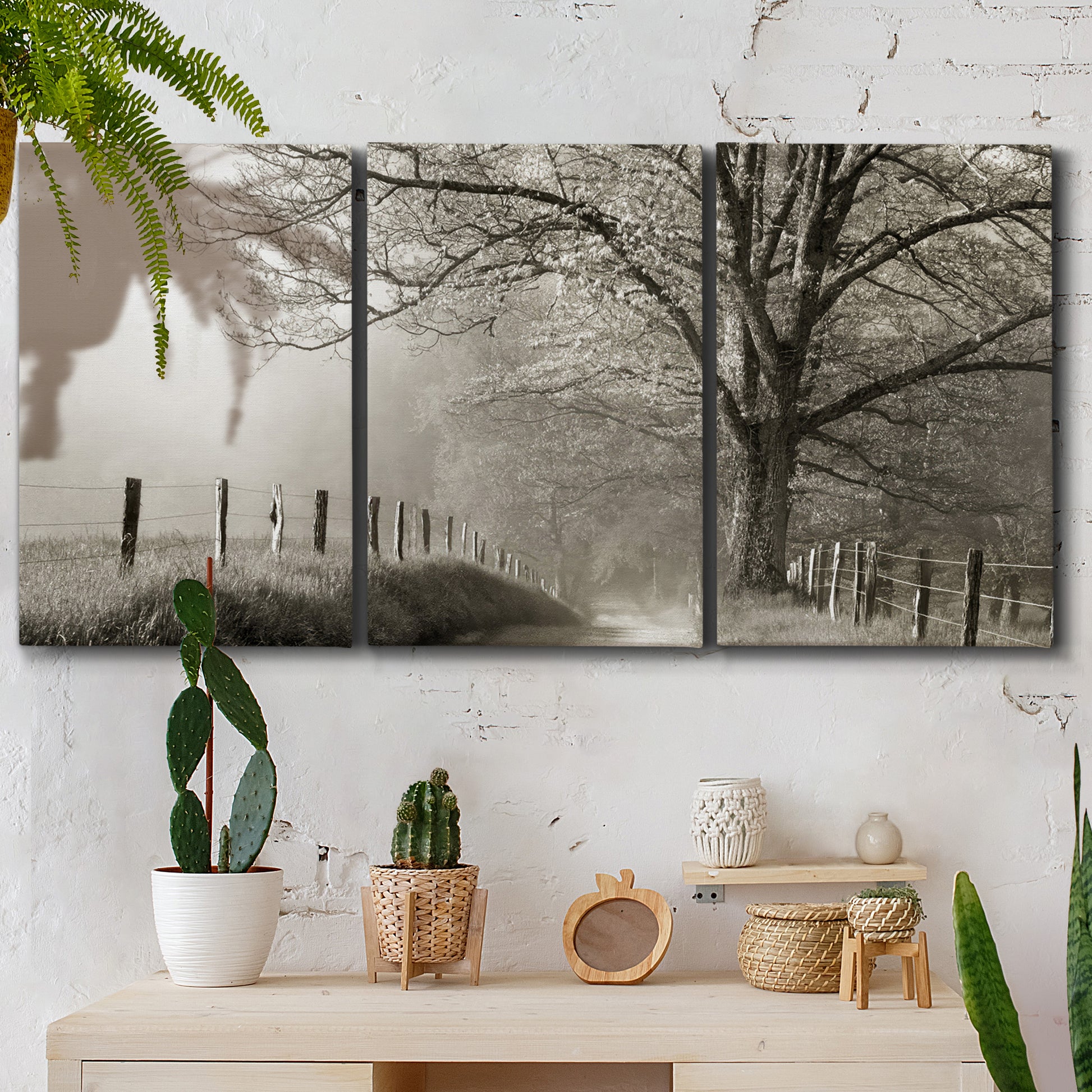 Three-panel canvas wall art featuring fenced rural path through countryside, displayed in a boho-chic entryway above a console table.