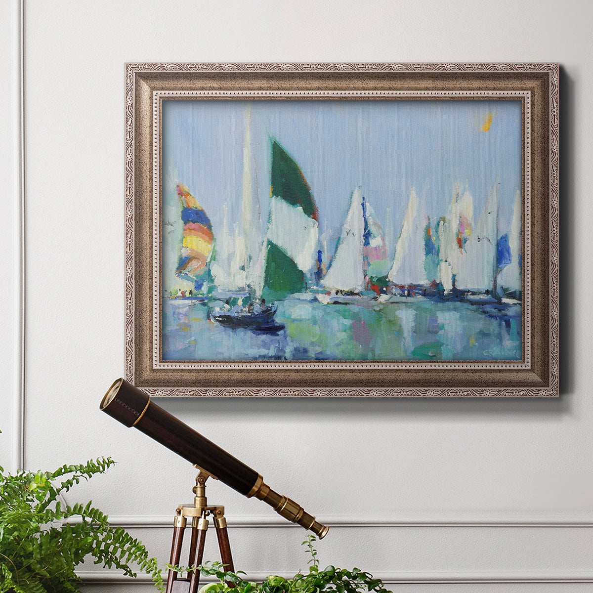 Coastal harbor watercolor painting in an ornate traditional silver frame displayed in a light-toned interior setting.