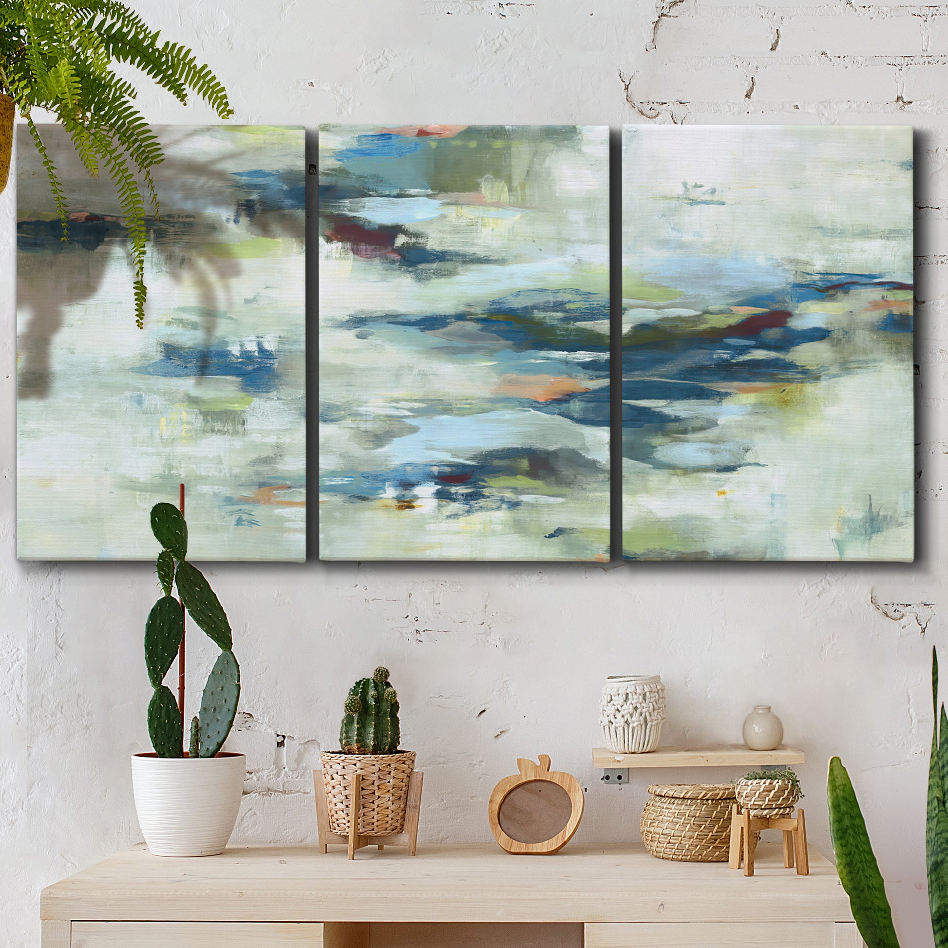 Three-panel canvas wall art featuring dreamlike abstract drifting motion, displayed in a boho-chic entryway above a console table.