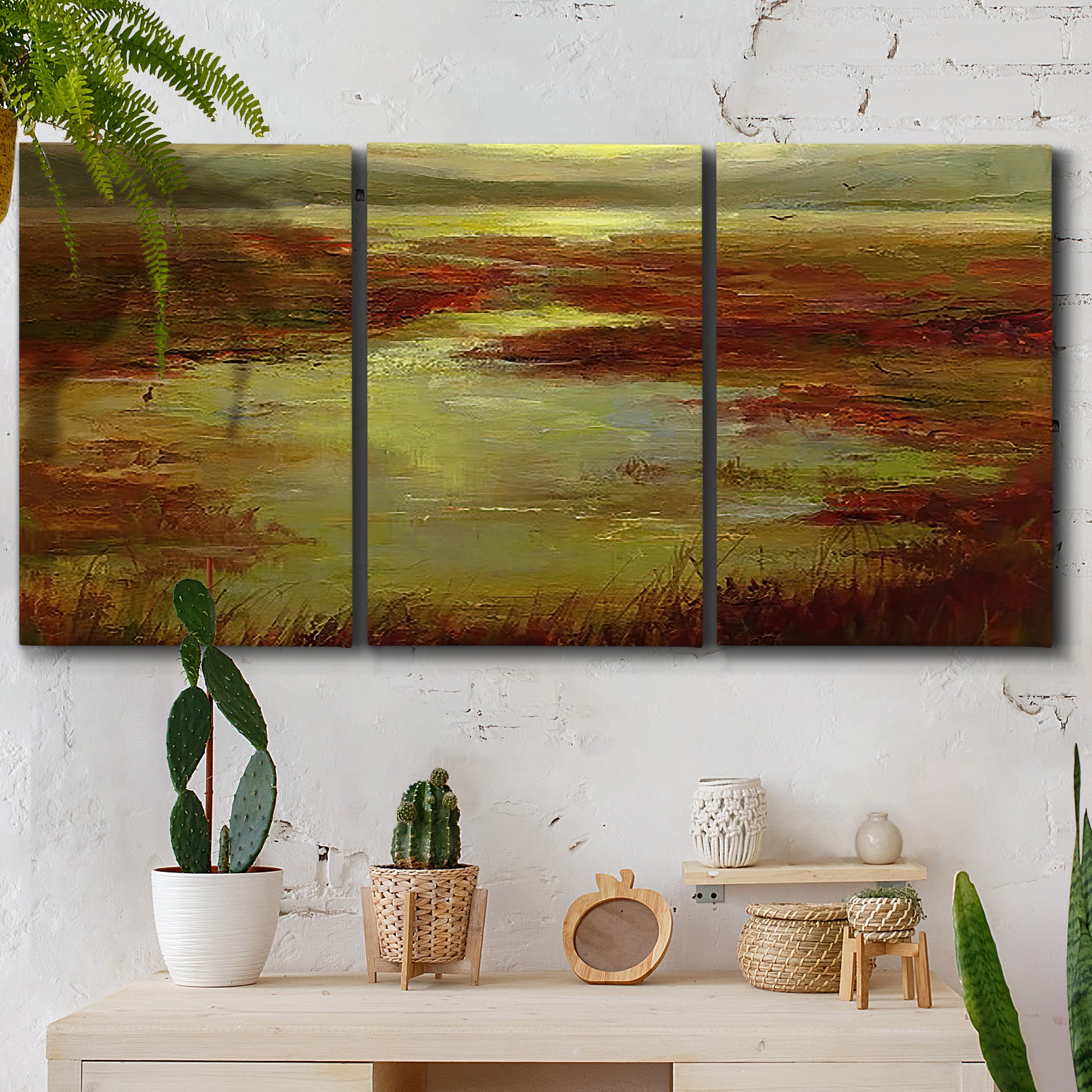 Three-panel canvas wall art featuring coastal shoreline with warm light, displayed in a boho-chic entryway above a console table.