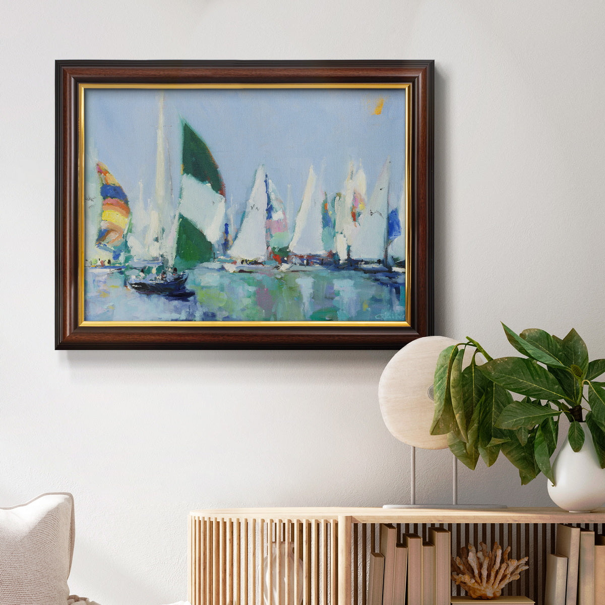 Coastal harbor watercolor painting in an ornate mahogany wood frame with gold liner displayed in a light-toned interior setting.