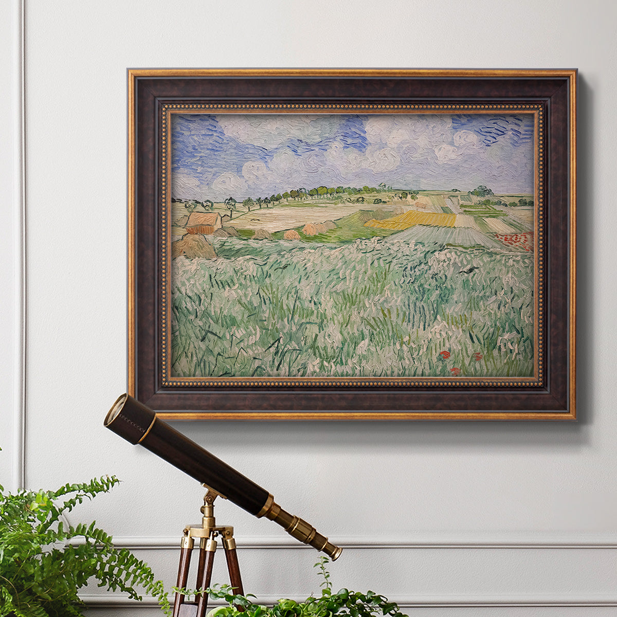 Impressionist countryside landscape near Auvers by Vincent van Gogh in an ornate bronzed mahogany wood frame displayed in a light-toned interior setting.