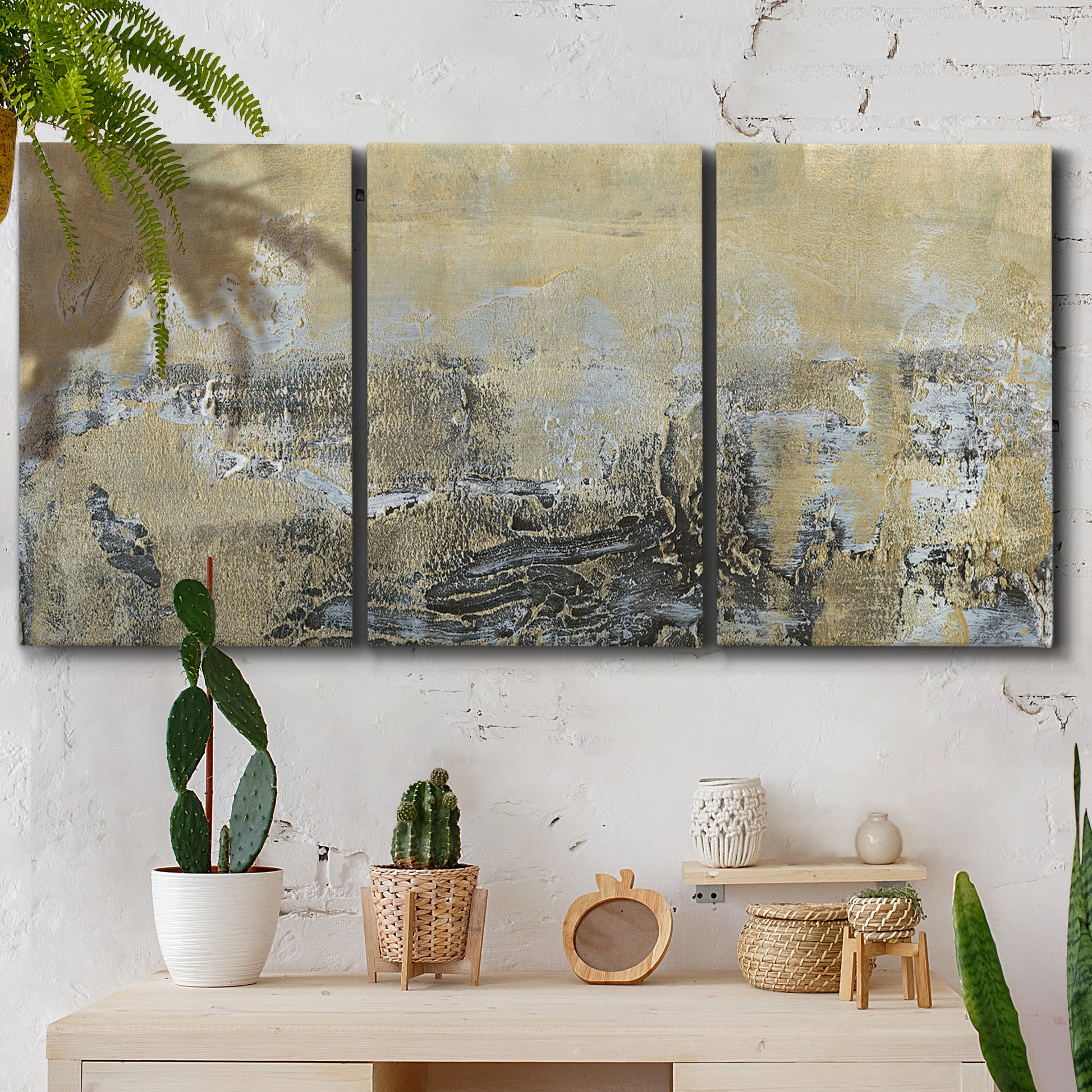 Three-panel canvas wall art featuring gold toned abstract horizon, displayed in a boho-chic entryway above a console table.