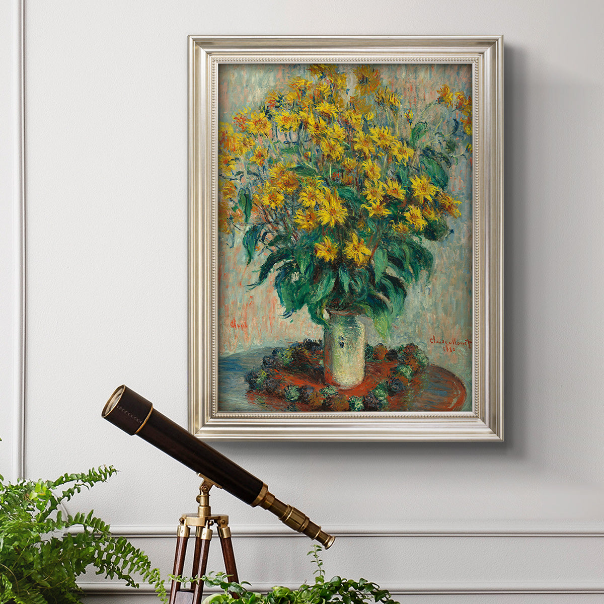 Impressionist floral painting of artichoke flowers by Claude Monet in an ornate champagne frame displayed in a light-toned interior setting.