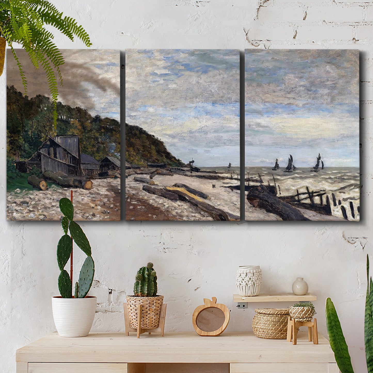 Three-panel canvas wall art featuring open sea along rocky shore, displayed in a boho-chic entryway above a console table.