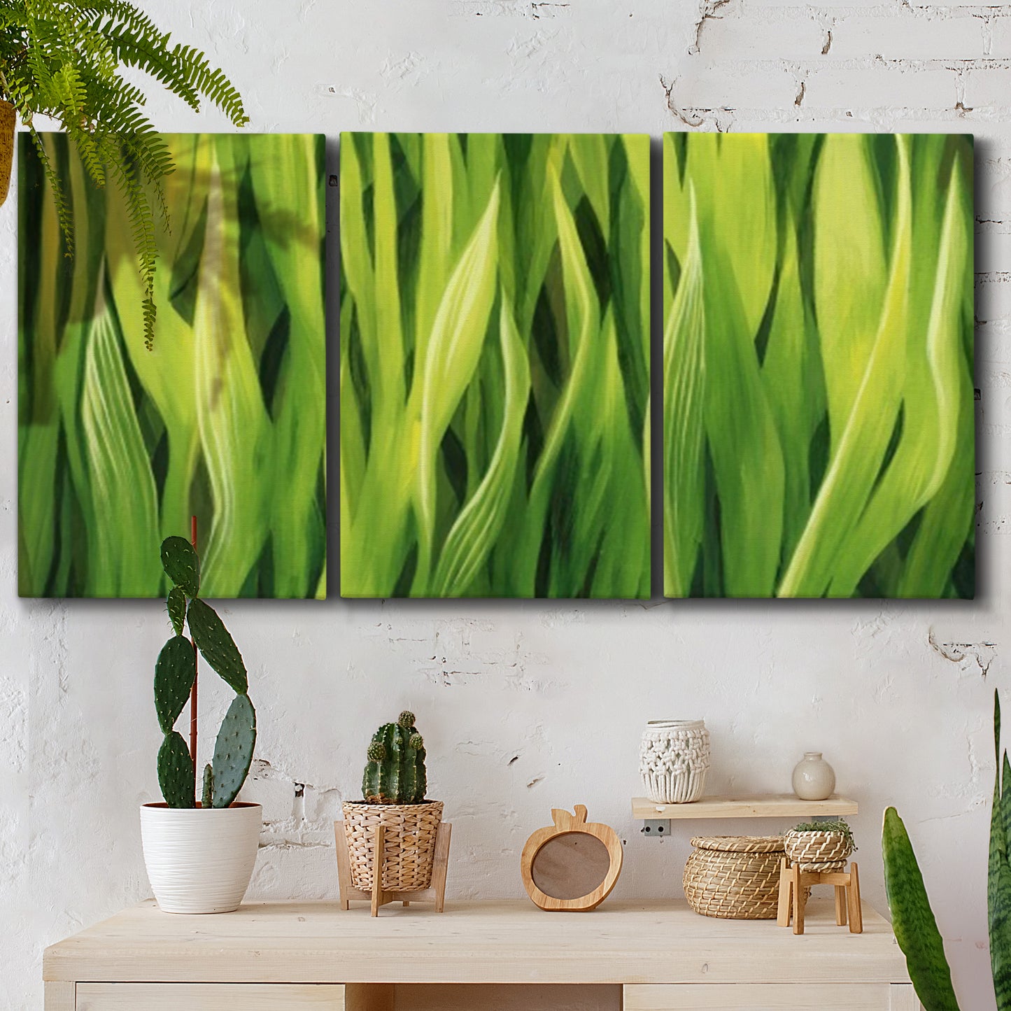 Three-panel canvas wall art featuring close view of tall green grass blades, displayed in a boho-chic entryway above a console table.