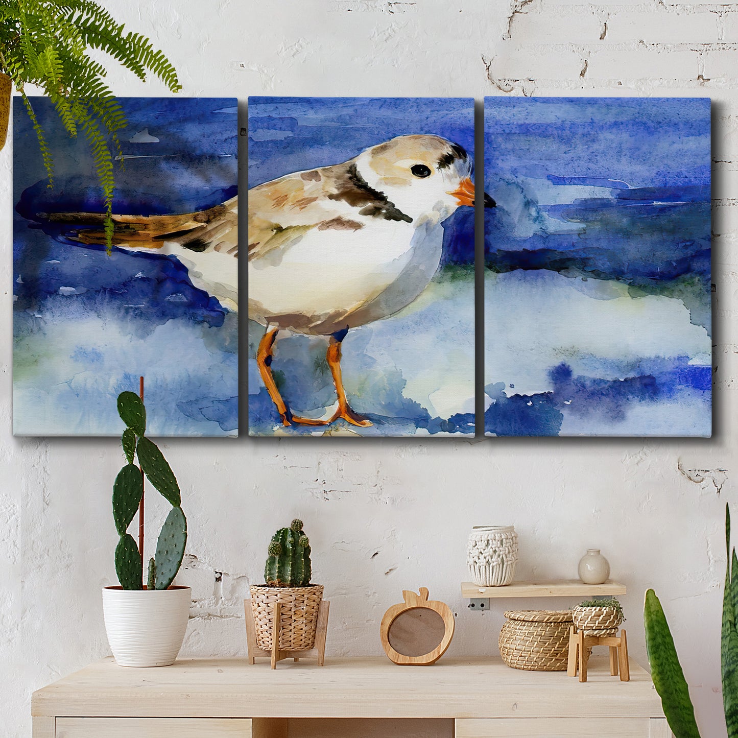 Three-panel canvas wall art featuring shorebirds standing in shallow water, displayed in a boho-chic entryway above a console table.