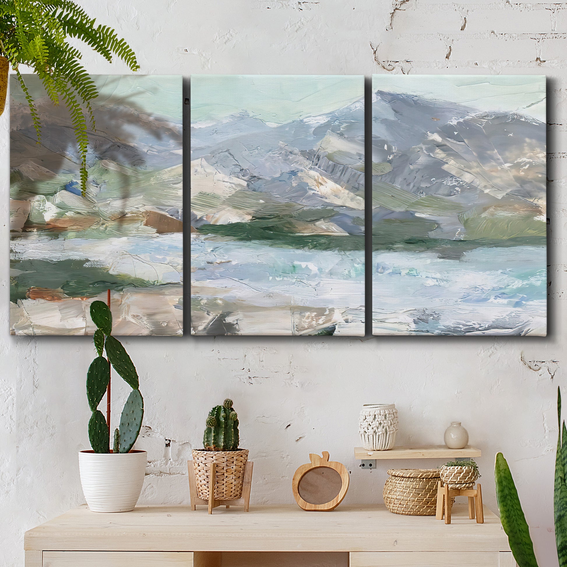 Three-panel canvas wall art featuring pastel mountain landscape view, displayed in a boho-chic entryway above a console table.