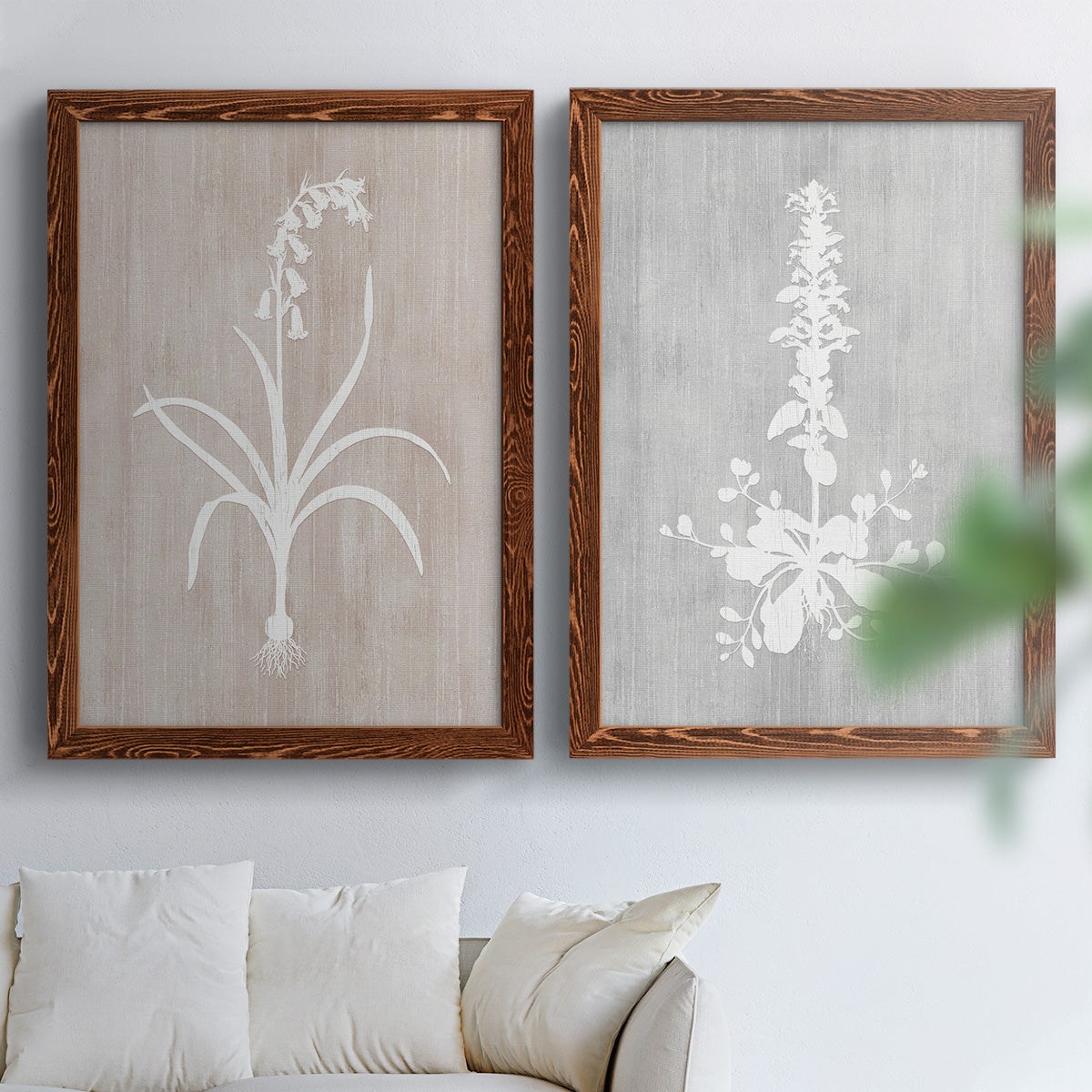 Set of two maple barnwood framed canvas prints depicting delicate stems, leaves, and blossoms against gray taupe and pale blue panels arranged across two complementary compositions above a sofa in a bright living space.