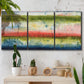 Three-panel canvas wall art featuring layered abstract color banding, displayed in a boho-chic entryway above a console table.