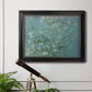 Impressionist flowering almond branch painting by Vincent van Gogh in an ornate black frame with gilded inner detail displayed in a light-toned interior setting.