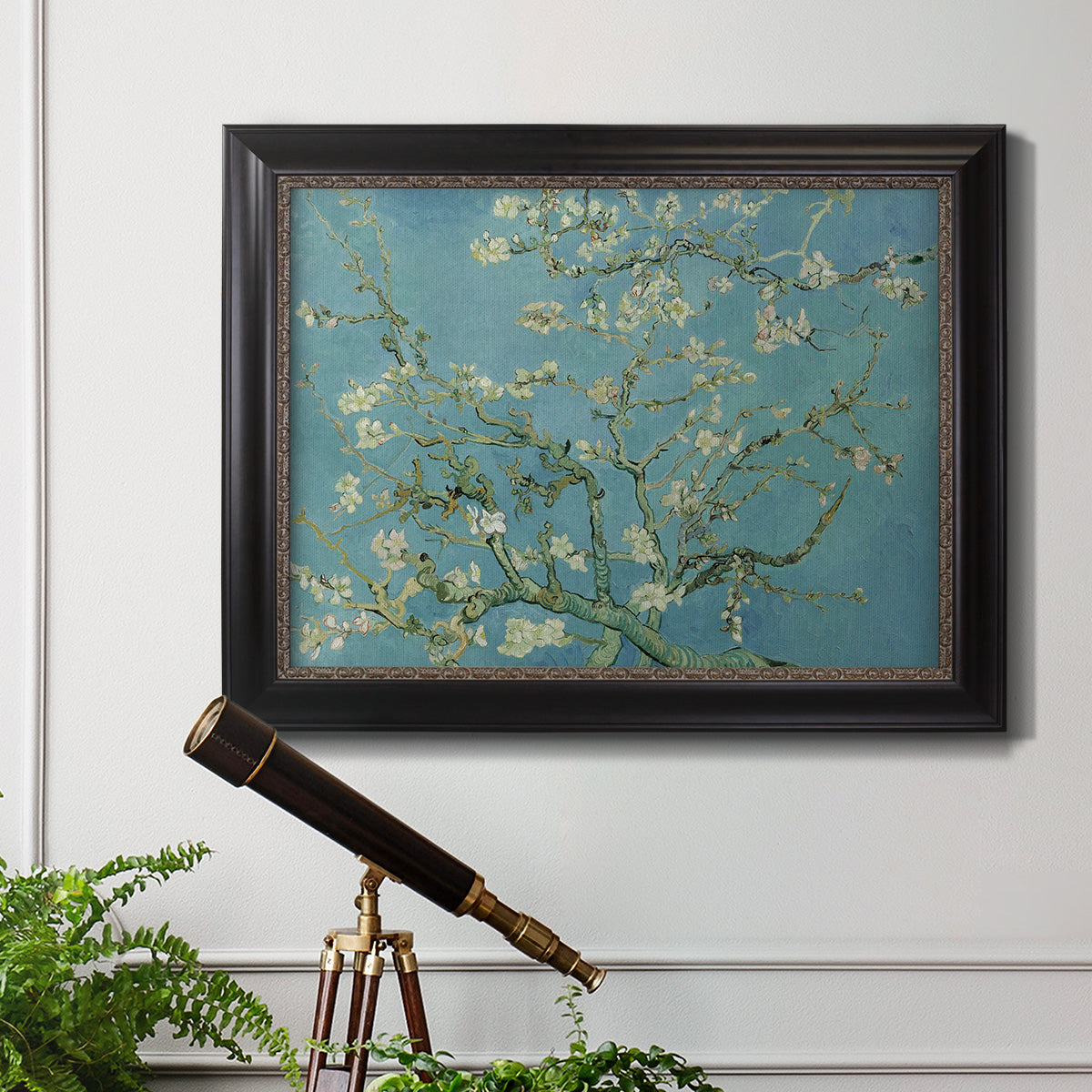 Impressionist flowering almond branch painting by Vincent van Gogh in an ornate black frame with gilded inner detail displayed in a light-toned interior setting.