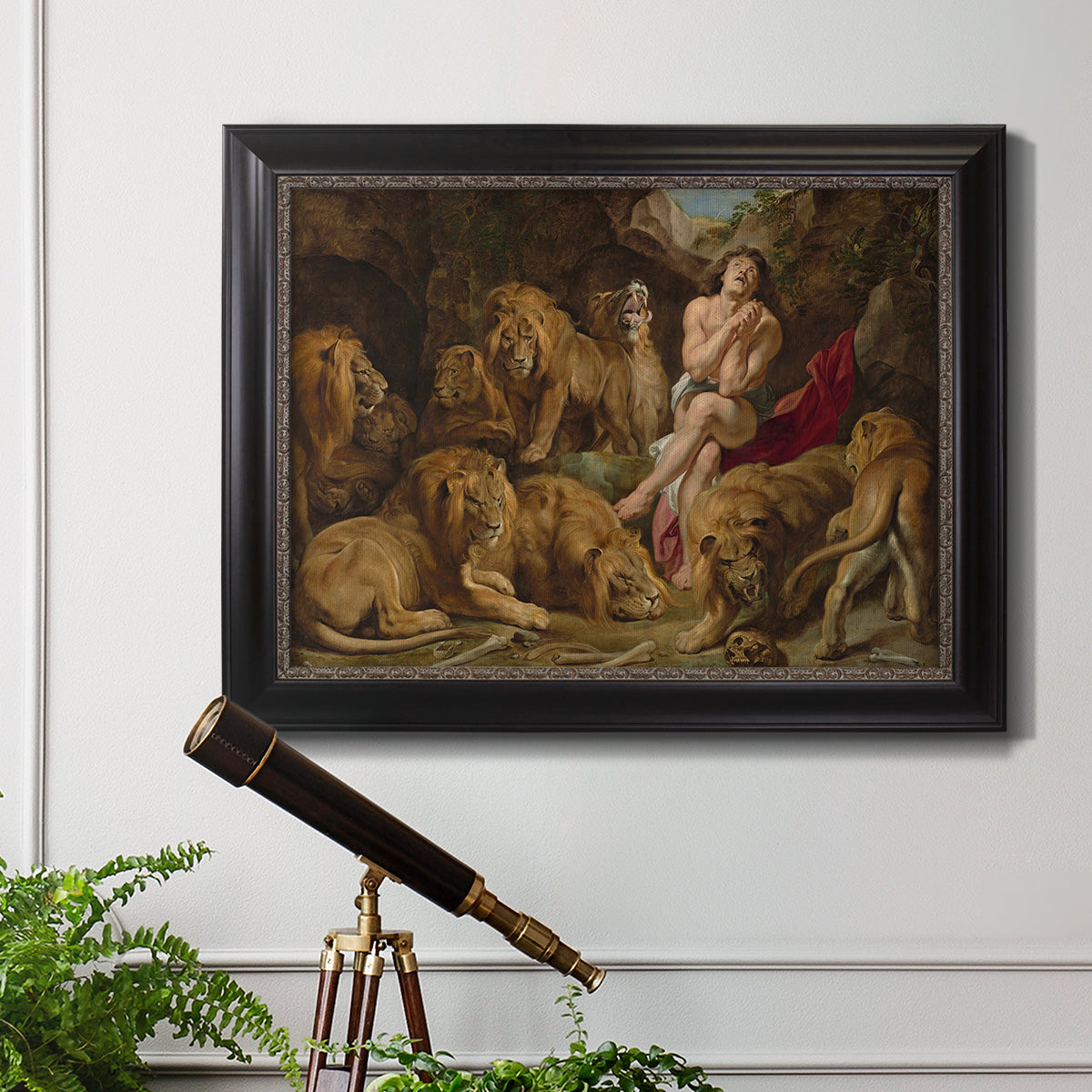 Dramatic biblical painting of Daniel with lions by Peter Paul Rubens in an ornate black frame with gilded inner detail displayed in a light-toned interior setting.