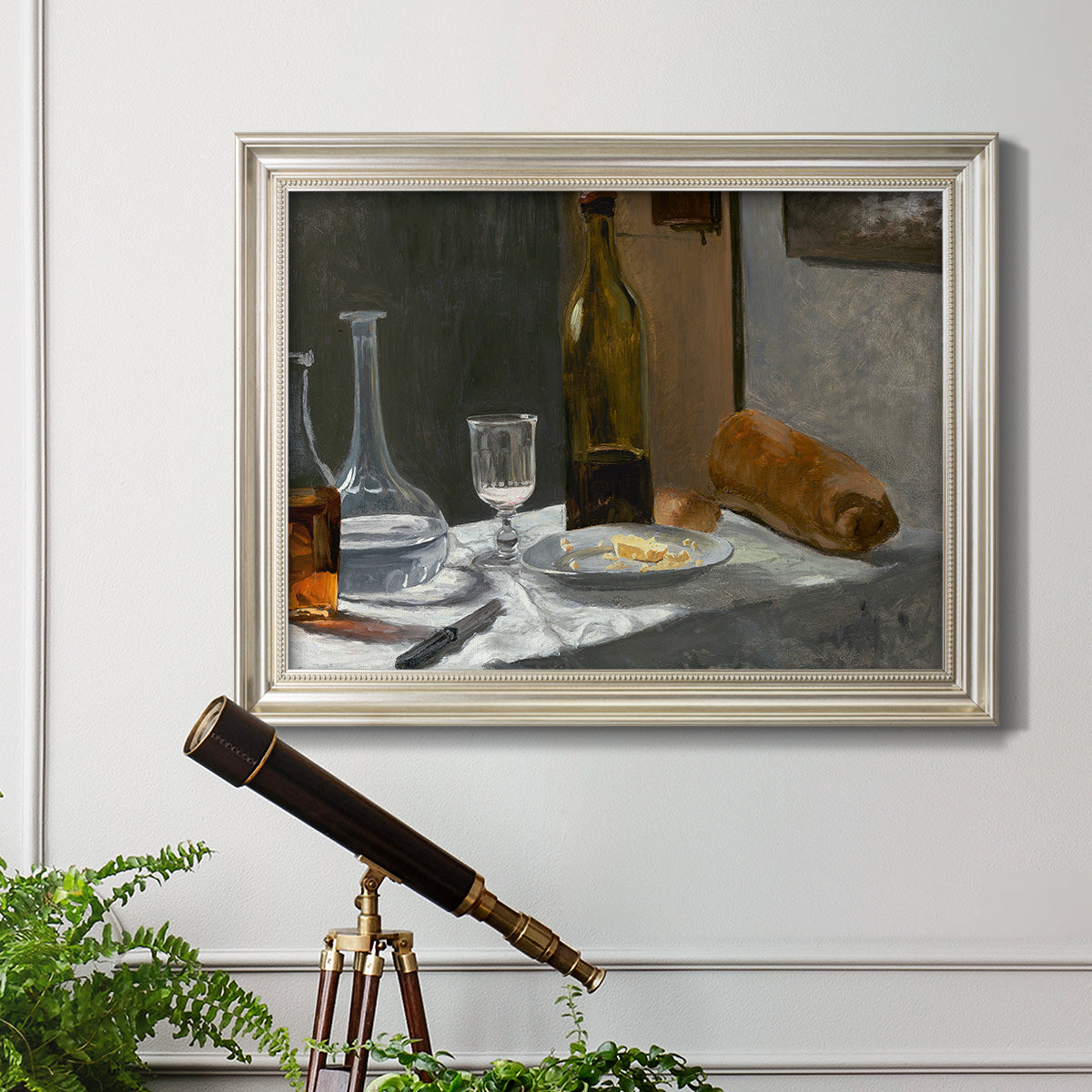 Impressionist still life with wine and bread by Claude Monet in an ornate champagne frame displayed in a light-toned interior setting.