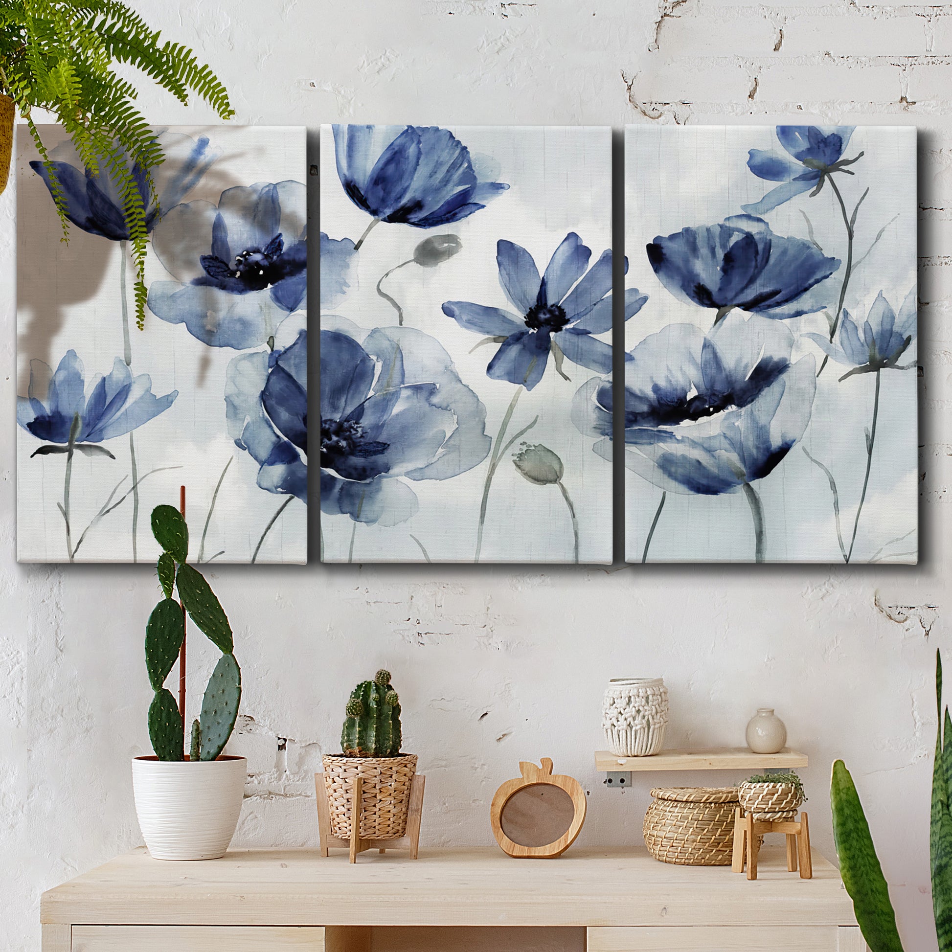 Three-panel canvas wall art featuring indigo floral blossoms awakening, displayed in a boho-chic entryway above a console table.