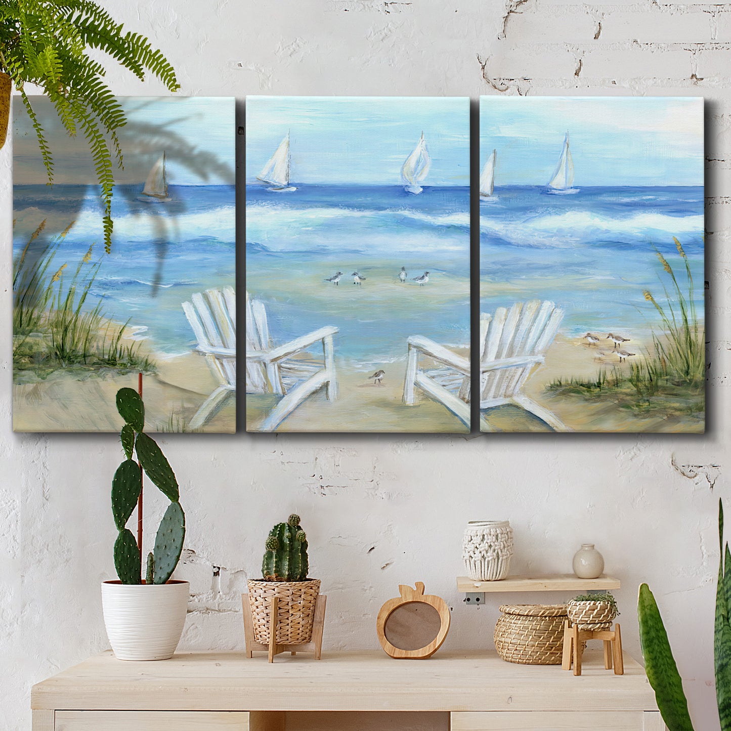 Three-panel canvas wall art featuring peaceful coastal landscape escape, displayed in a boho-chic entryway above a console table.