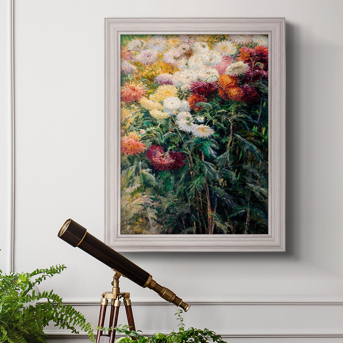 Impressionist garden floral painting by Gustave Caillebotte in an ornate weathered white frame displayed in a light-toned interior setting.