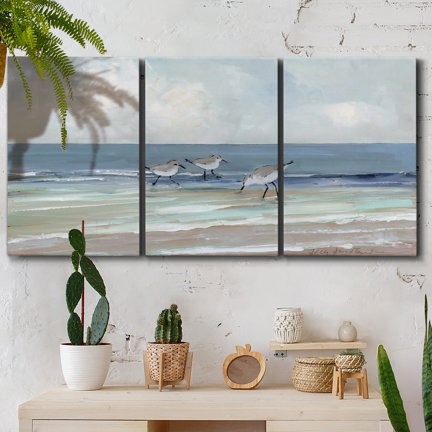 Three-panel canvas wall art featuring shore birds searching along beach, displayed in a boho-chic entryway above a console table.