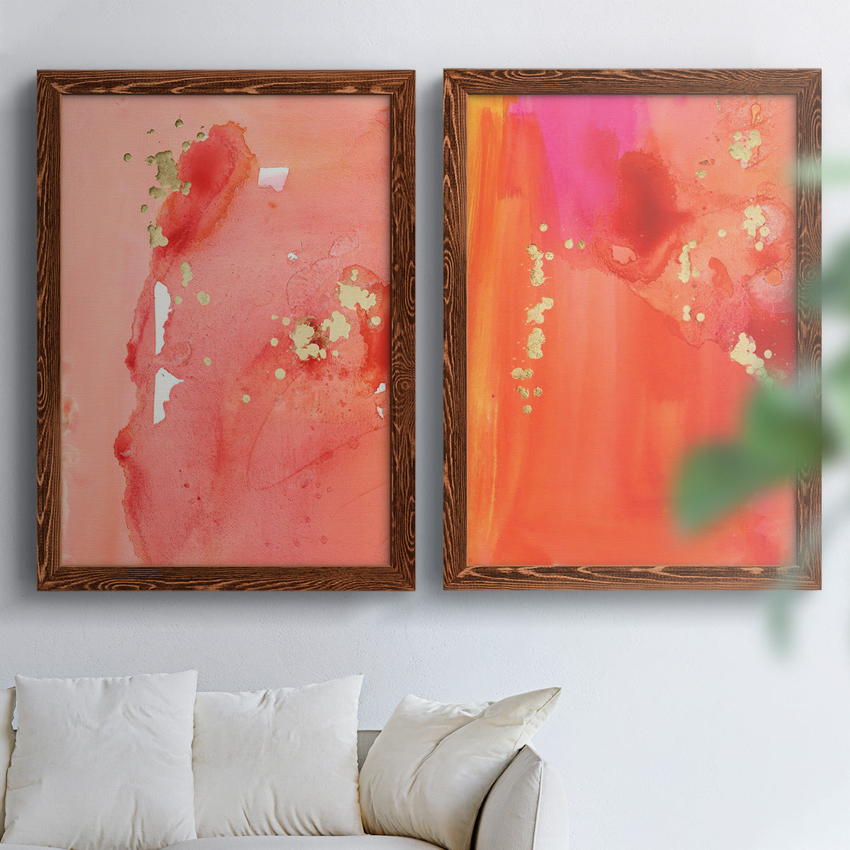 Set of two maple barnwood framed canvas prints depicting translucent warm washes, drips, and scattered metallic accents arranged across two complementary compositions above a sofa in a bright living space.