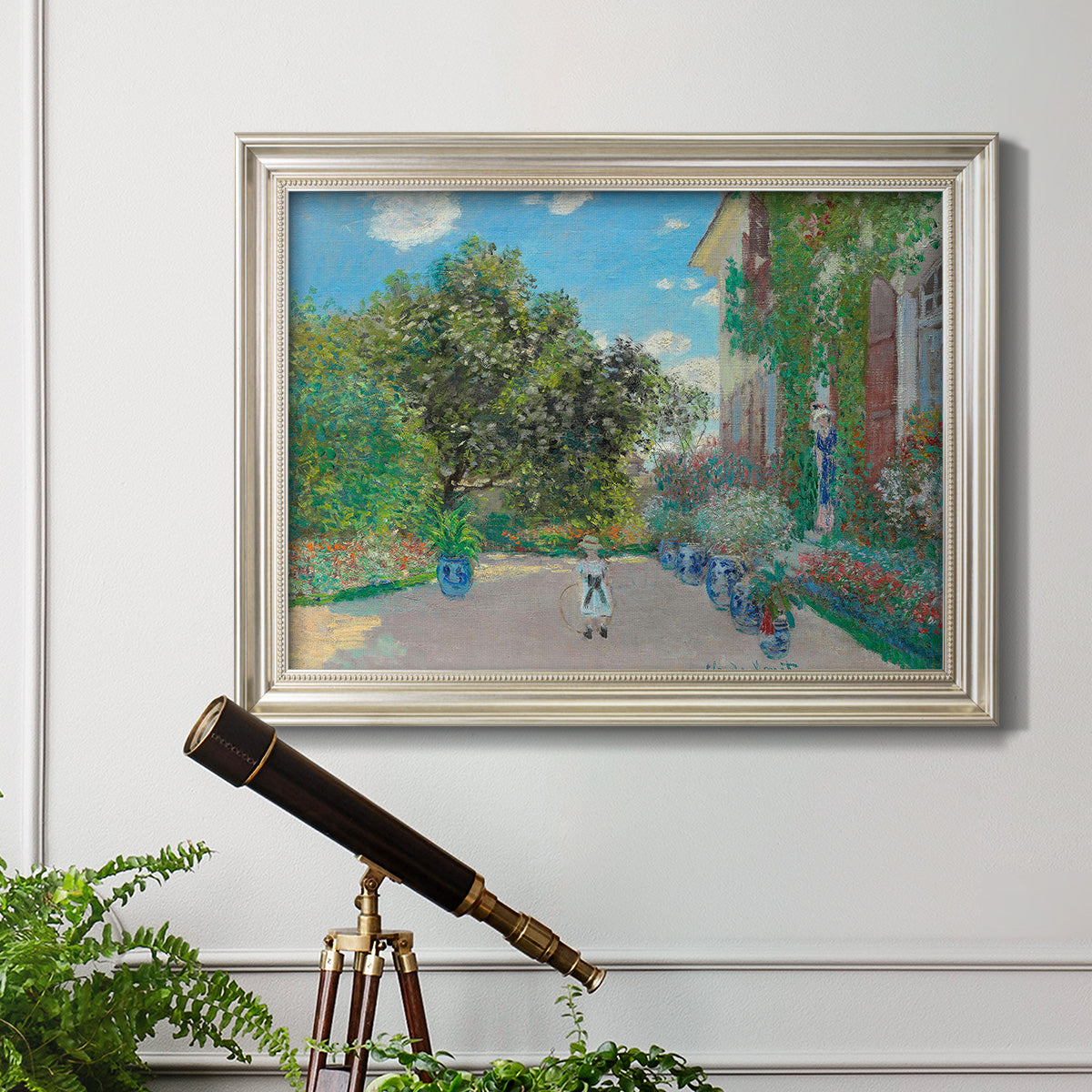 Impressionist residential landscape at Argenteuil by Claude Monet in an ornate champagne frame displayed in a light-toned interior setting.